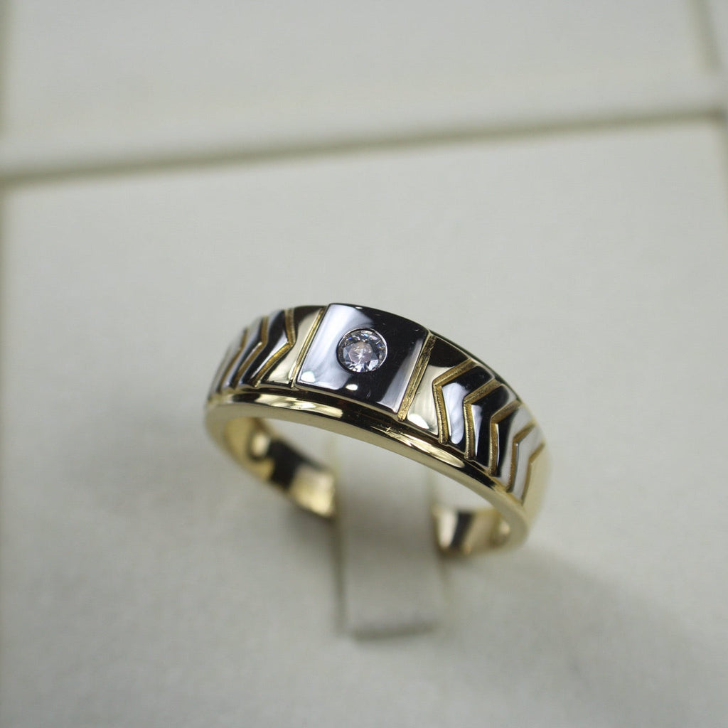 Gold and silver ring with a diamond on a light background