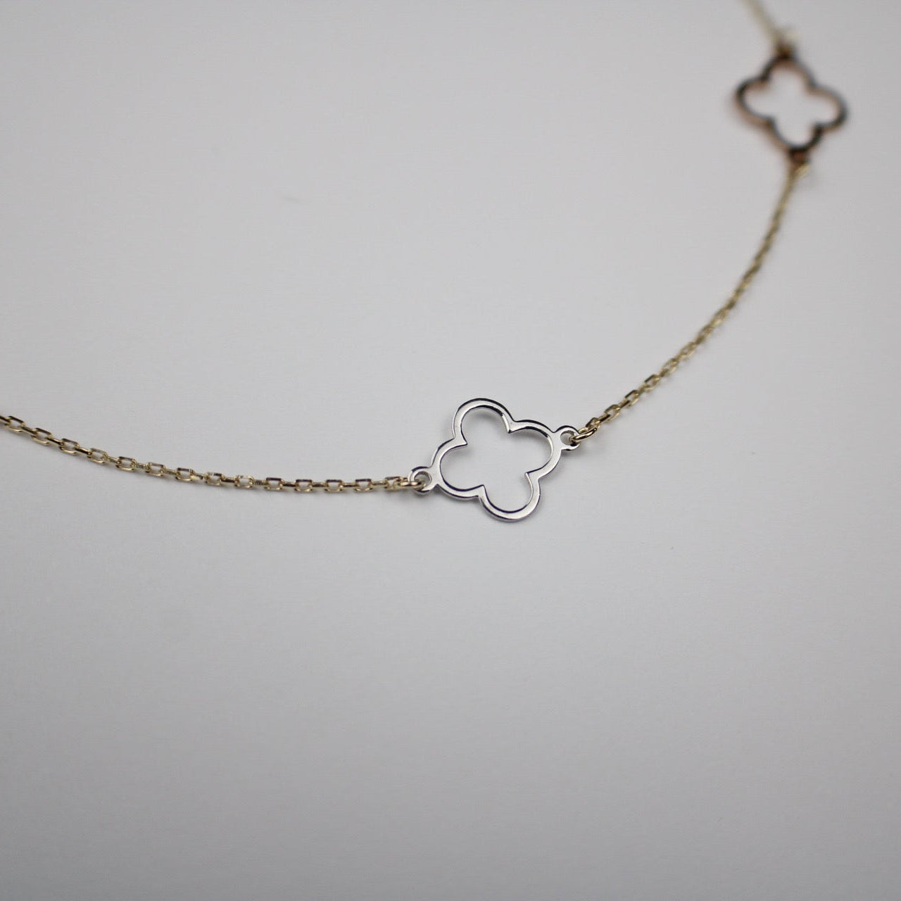 Necklace with clover-shaped pendants on a light gray background