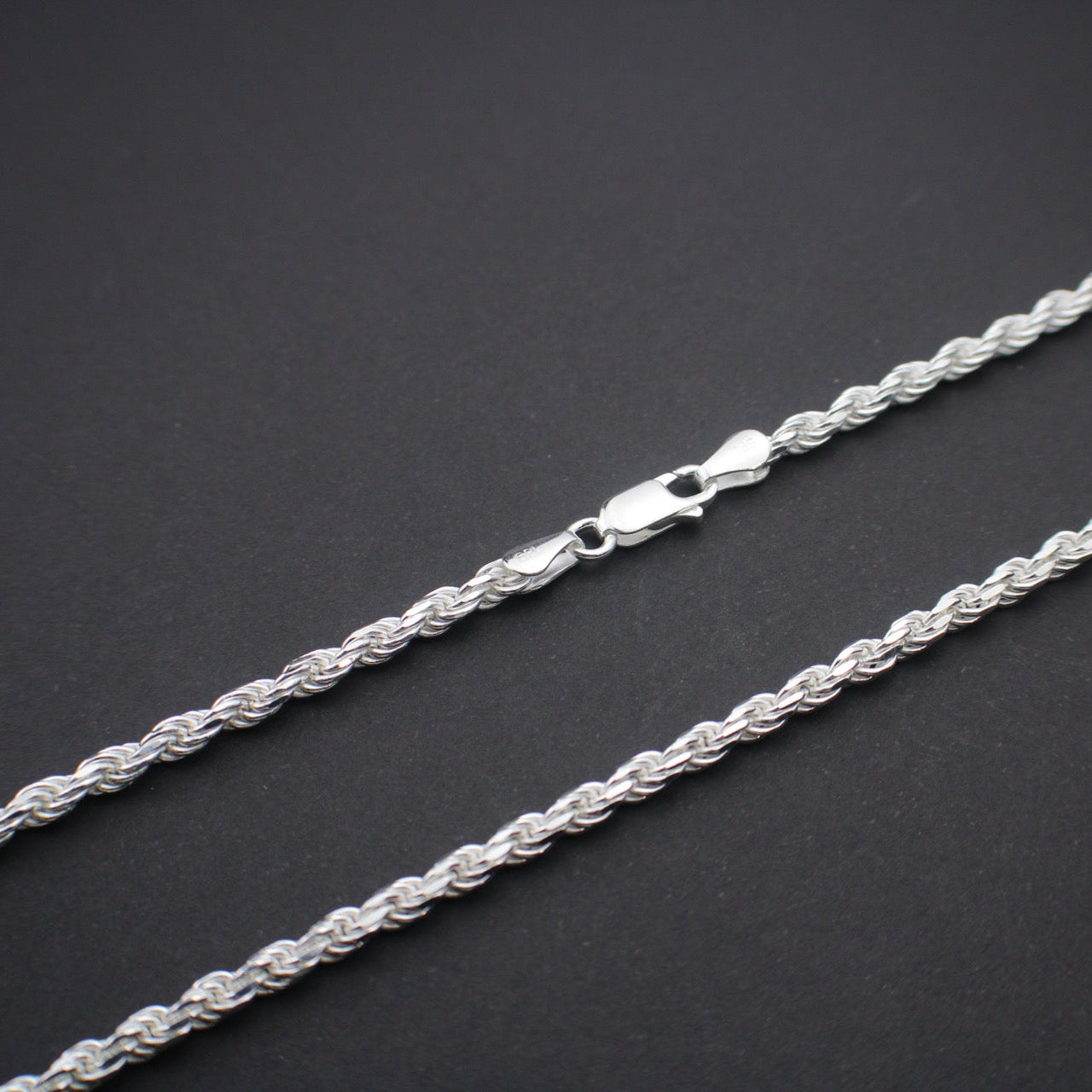 Silver rope chain on a dark gray background