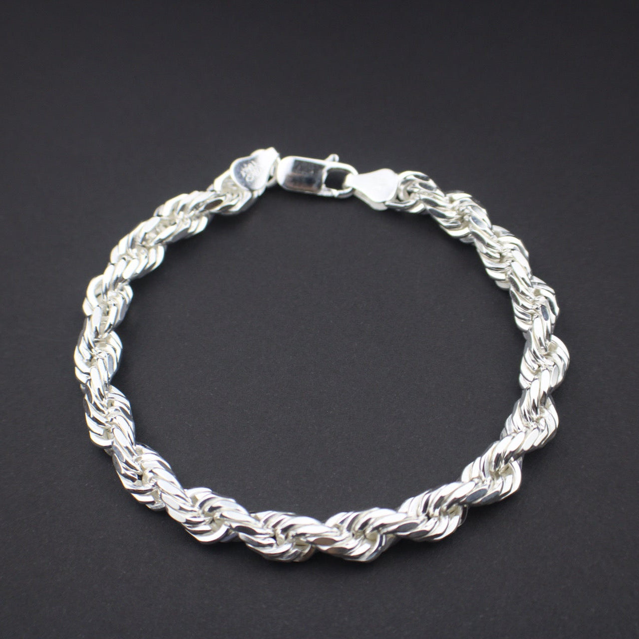 Silver rope-style bracelet on a black background