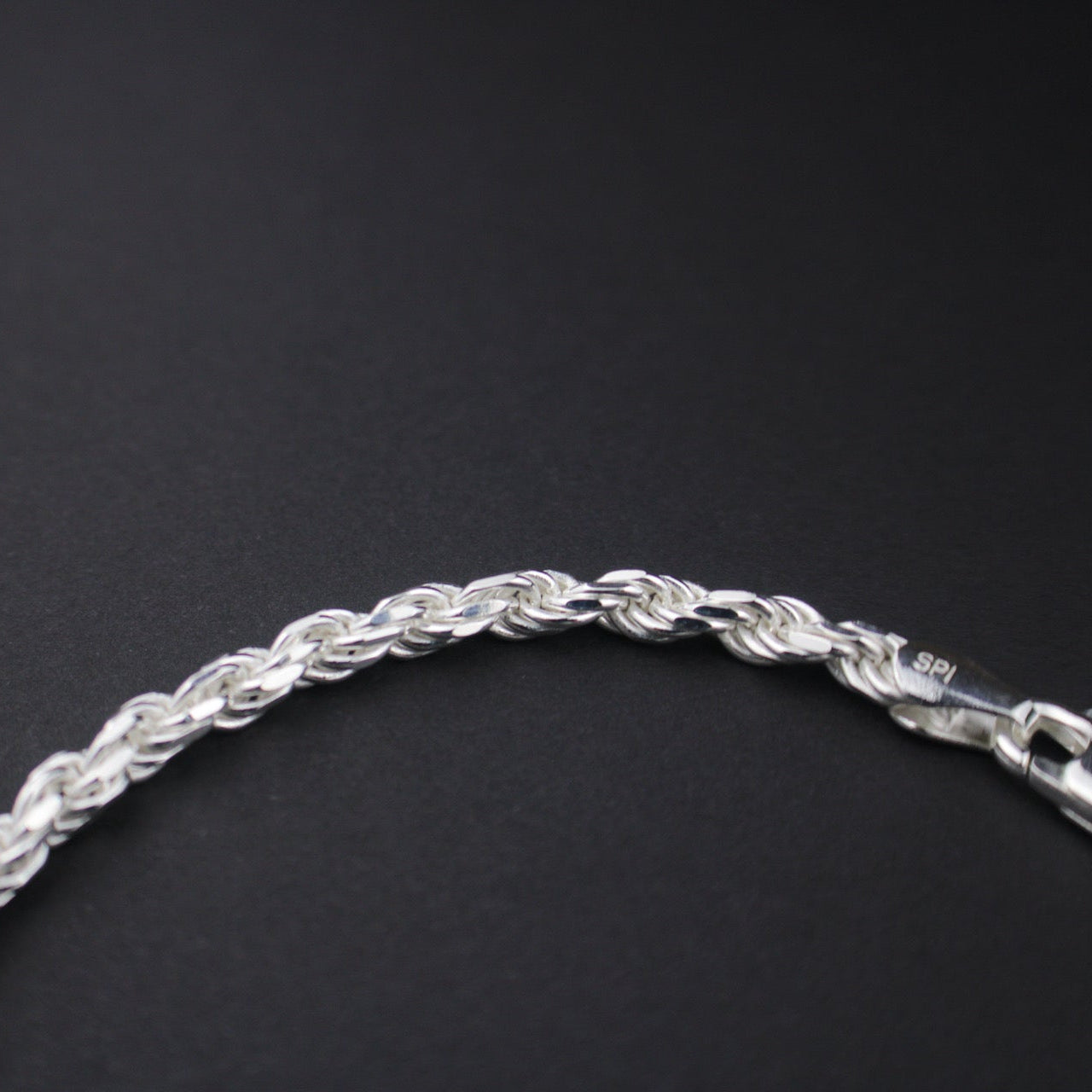 Silver chain bracelet on a black background