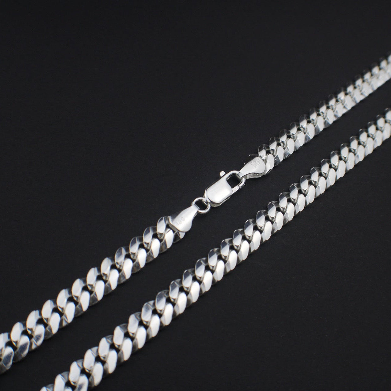 Silver chain necklace on a black background